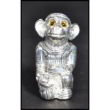 A silver plated pin cushion in the form of a monkey wearing a hat in royal dress.