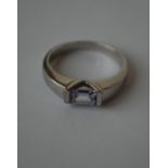 A hallmarked 9ct white gold ring  being set with a pale purple emerald cut stone.  Hallmarked