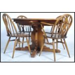 Ercol - Chester - A retro 1980's elm round extending table raised on the cross wide splayed legs