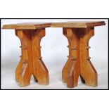 A pair of solid heavy oak ecclesiastical refectory stools of planked cross over construction with