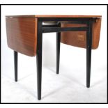 A vintage retro 20th century teak drop leaf extending dining table raised on tapering ebonised