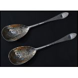 A pair of early 20th century Edwardian silver hallmarked gilt serving spoons having engraved bowls