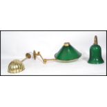 A group of three brass wall light fixtures to include two with green glass shades and another with a