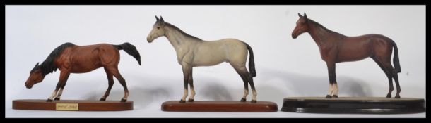 A group of three Beswick / Royal Doulton ceramic horses on plinth bases to include a Beswick grey