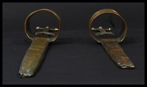 A pair of antique brass and steal bladed African arm daggers with engraved stylised floral and other