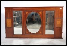 An Edwardian mahogany inlaid large overmantel mirror having central bevelled oval mirror flanked