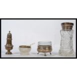 A group of silver items to include a hallmarked silver topped and cut glass tall sugar shaker sifter