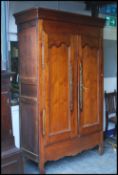 A 19th century French provincial chestnut armoire. The upright body with twin full length doors