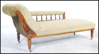 A Victorian 19th century oak chaise longue / day bed with carved scrolling head rest, open arm