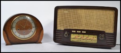 A vintage mid 20th century bakel;ite valve radio together with an oak cased mantle clock with a