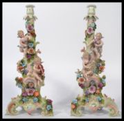 A pair of 19th century Continental believed Meissen / Sitzendorf candlesticks raised on scrolled
