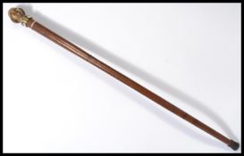 A vintage 20th century walking stick cane having a tapering wooden shaft with brass and silver white