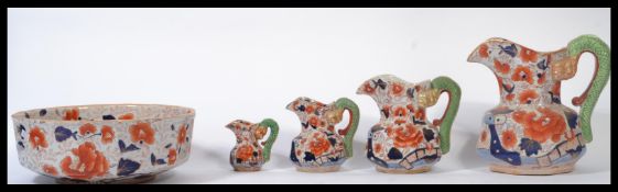 A collection of four graduating 20th century Ironstone hydra jugs together with a matching bowl, all