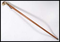 A vintage 20th century walking stick cane having a tapering wooden shaft with brass collar and the