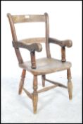 A 19th century beech and elm country childs windsor chair of rustic form being raised on shaped legs