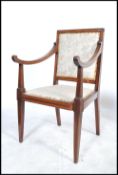 An Edwardian mahogany inlaid salon armchair being raised on square tapering legs with bow shaped