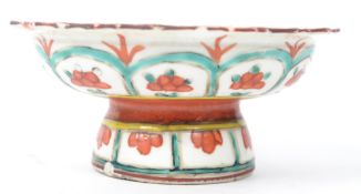 An Oriental Chinese raised tazza dish having a scalloped edge with hand painted floral and geometric