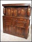A 1930's oak court cupboard with upper cupboard, two cupboards and two drawers. Measures: 131cm high