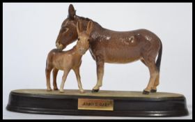 A Beswick figure group of a donkey and foal, on an oval base applied with plaque inscribed `Jenny`