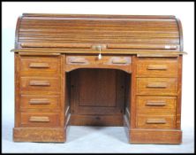 A vintage early 20th Century oak roll top tambour fronted twin pedestal roll top desk, the desk