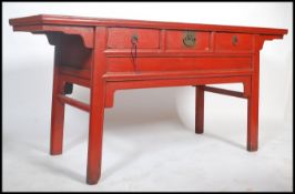 A 20th century large Chinese red lacquered sideboard / console table believed to be from the north