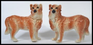 A pair of large 19th century Staffordshire pottery fireside dogs, decorated in reddish brown tones