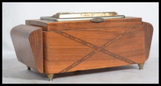 An early 20th century mahogany inlaid metamorphic sewing box with white metal plaque of landscape of