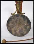 A vintage early 20th century wall mounted gong of brass construction on a wooden mount complete with