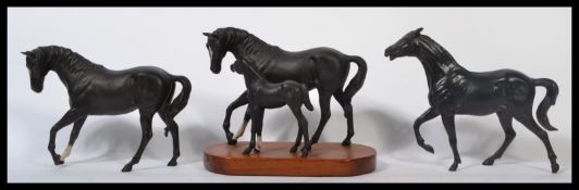 A group of three ceramic figurines of black horses to include a Beswick black beauty horse , a horse