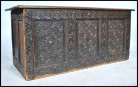 An 18th century country oak coffer having carved fielded panels with geometric design surmounted