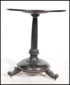 A 19th century Victorian mahogany pedestal table having an ebonised finish being raised on