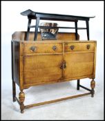 A 1930's Art Deco oak sideboard raised on bulbous legs with twin cupboard doors having a stage