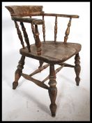 A Victorian beech and elm smokers bow - windsor armchair. Raised on turned legs united by stretchers