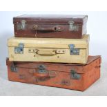 A collection of vintage retro suitcases to include leather examples, some with remnants of
