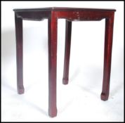 A Chinese square hardwood and marble topped side table, carved with scrolling foliage, raised on