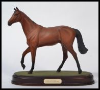 A Royal Doulton figurine of a race horse 'Red Rum', model No. DA18 on wooden plinth base. Measures