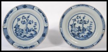 A pair of early to mid 18th century English Liverpool factory Delft charger plates hand painted with