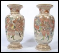 A pair of late Meiji period Oriental Japanese Satsuma vases hand painted with scenes of warriors and