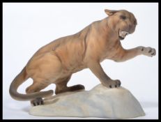 A Beswick model of a brown puma raised on a rocky outcrop. Transfer printed mark. Impressed
