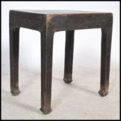 A 20th century Chinese opium stool / occasional in elm wood having an ebonised lacquered finish. The