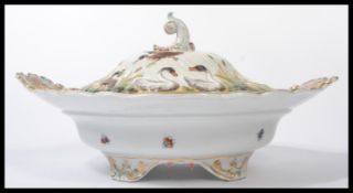 A 19th century ceramic platter tureen and cover depicting swans and cranes with insects. Floral