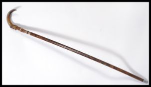 A vintage 20th century walking stick cane having a tapering wooden shaft with white metal silver