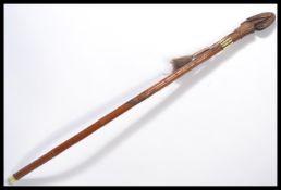 A vintage 20th century walking stick cane having a tapering wooden shaft carved with monkeys and