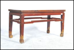 A 20th century Chinese red lacquered and gilt coffee table. The table raised on squared legs with