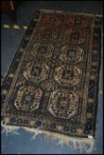 An Oriental Khotan style wollen rug having central design of 10  medallions to large field with