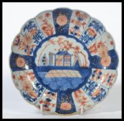 An Oriental Chinese Kangxi period (1690-1720) Imari pattern scalloped edge plate hand painted with