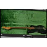 A vintage cased 20th century black bodied bass guitar by encore with a green velvet lined flight