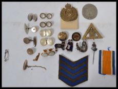 A collection of vintage 20th century items to include military buttons, cap badges, enamel badges