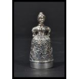 A sterling silver pin cushion and thimble in the form of a lady in dress. Weighs 23 grams.