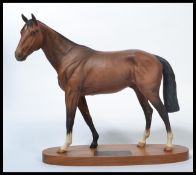 A Beswick connoisseur model Troy racehorse of the year 1979 matt brown on wooden plinth. Measures